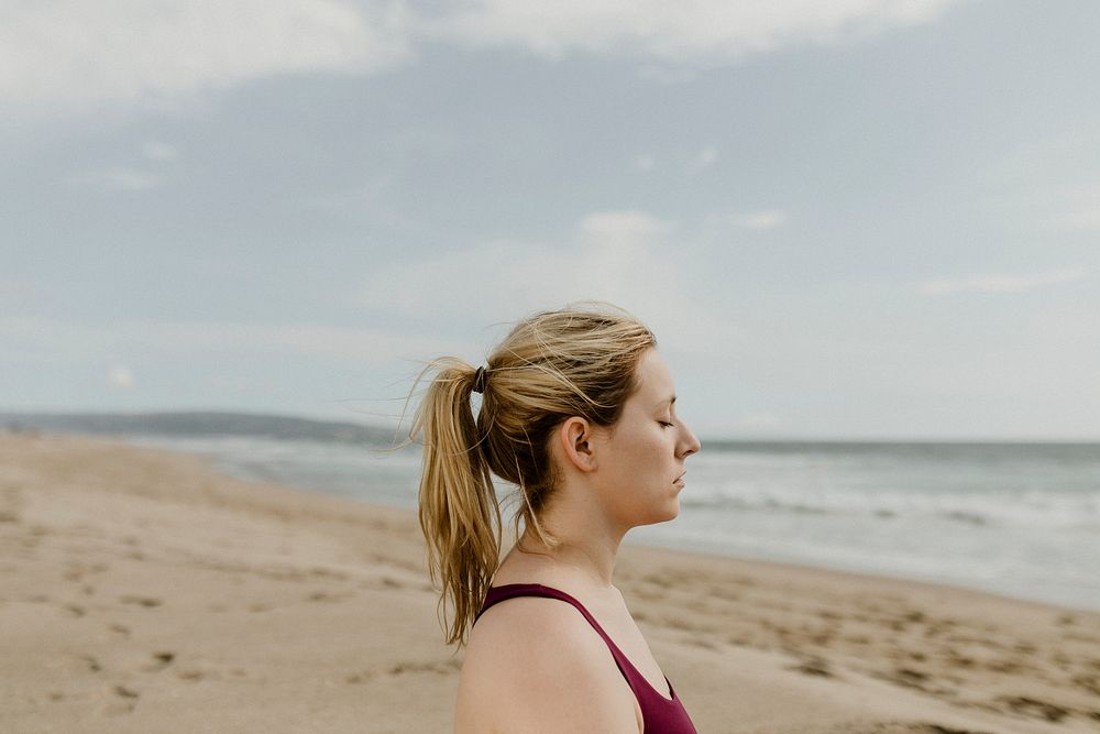 Woman meditating on the beach