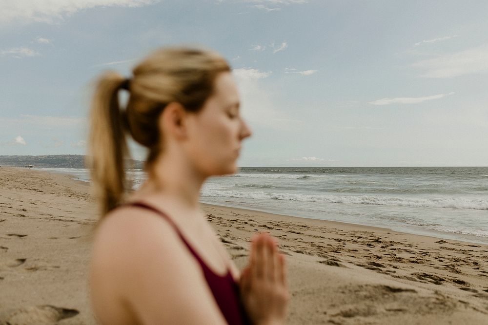 Woman practicing yoga on the beach