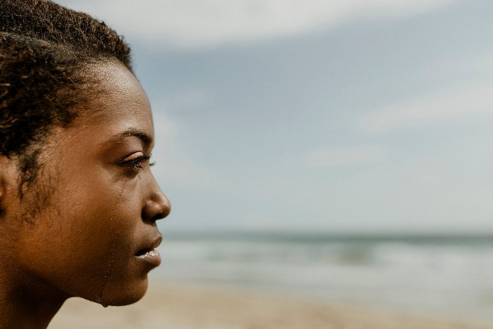 Black woman meditating on the beach