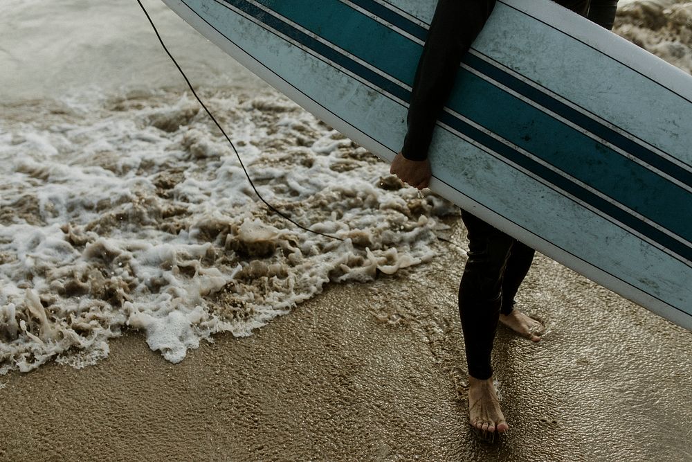 Man at the beach with his surfboard