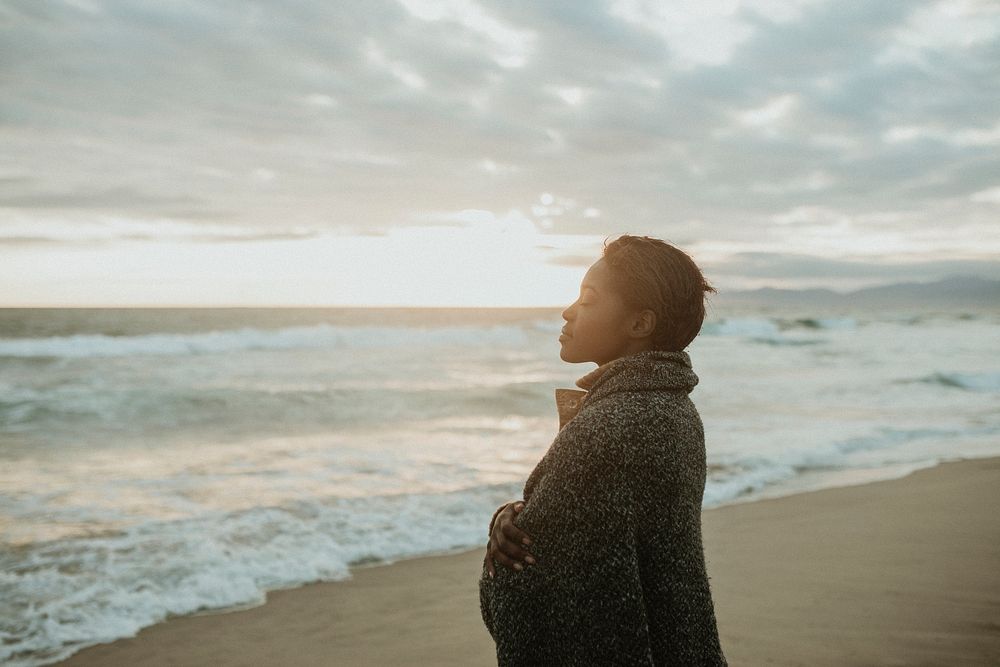 Black woman on the beach at sunset