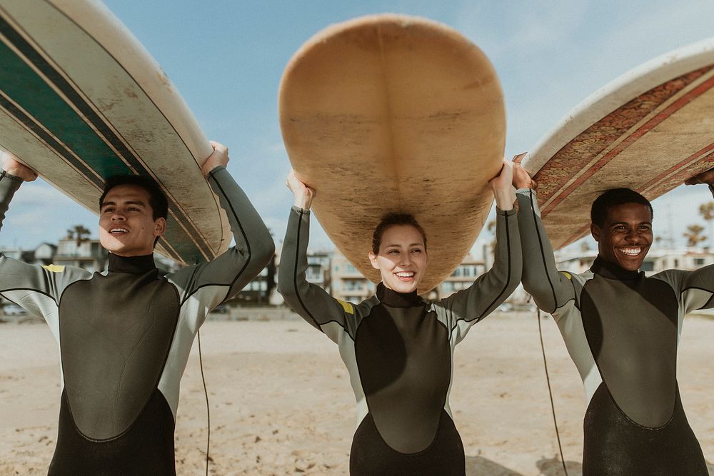 Happy friends surfing at the beach