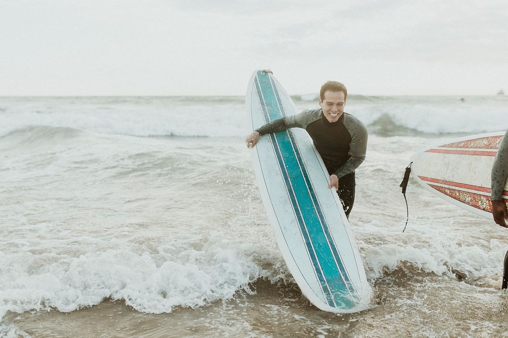 Cheerful man surfing at the beach