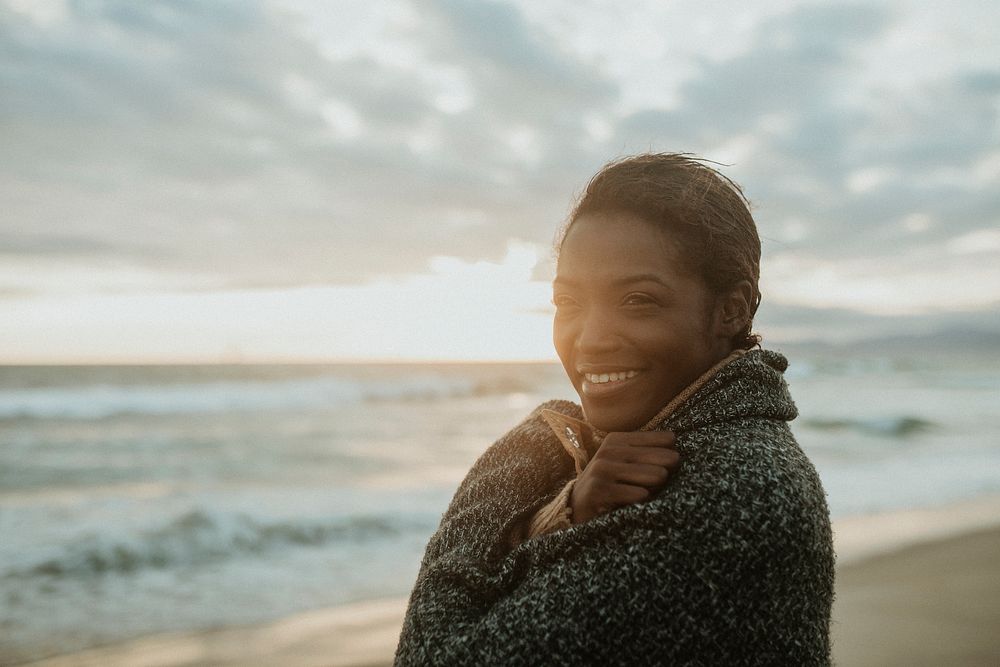 Cheerful woman on the beach on a cold summer night