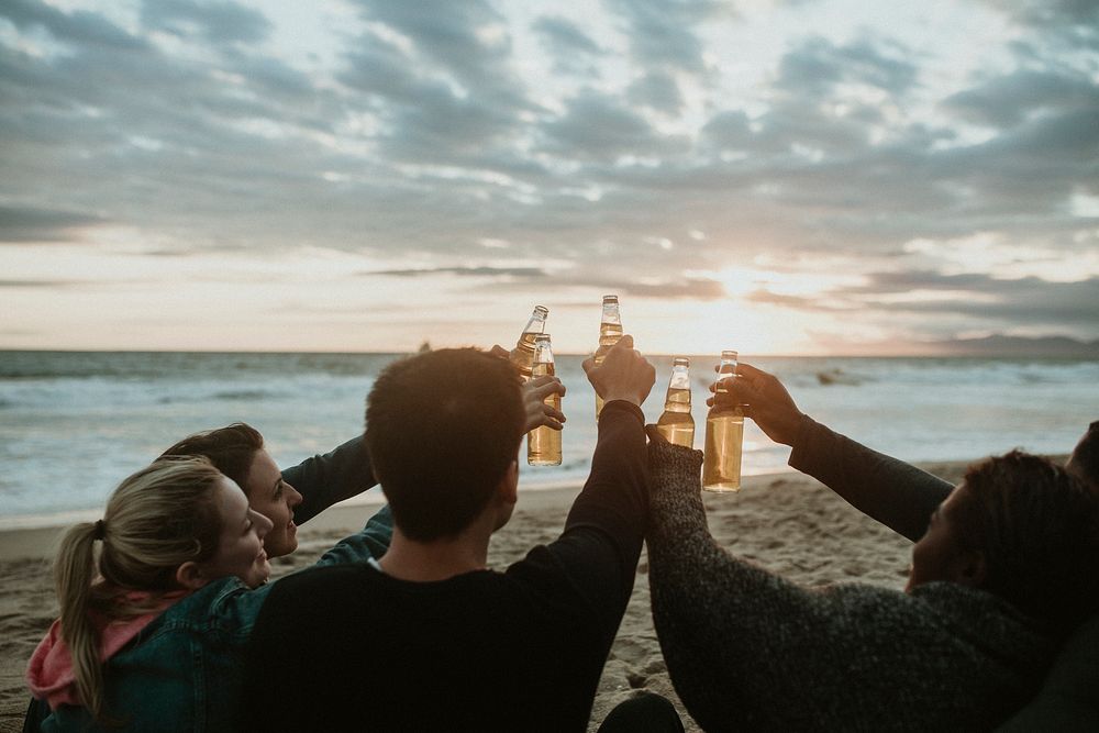 Happy friends toasting at the beach