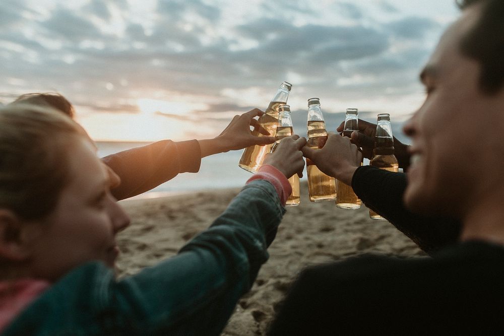 Happy friends toasting at the beach