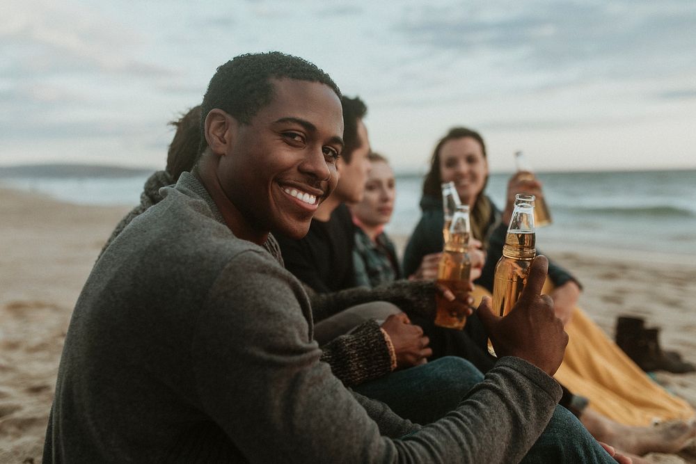 Cheerful friends drinking by the seaside
