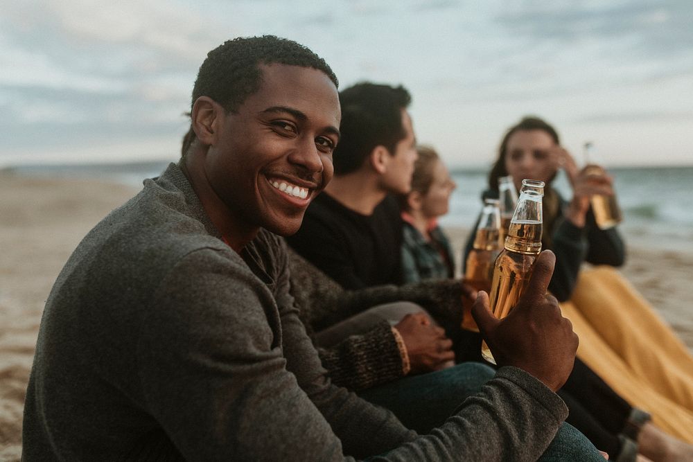 Cheerful friends drinking by the seaside
