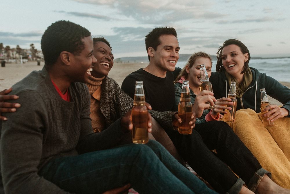 Cheerful friends drinking by the seaside