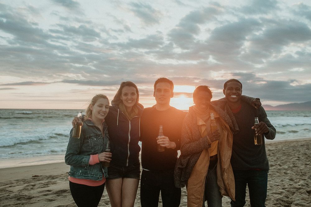 Cheerful friends drinking on the beach