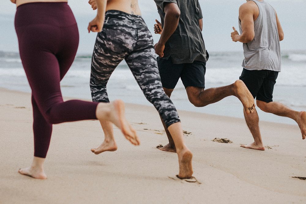 Friends running together at the beach