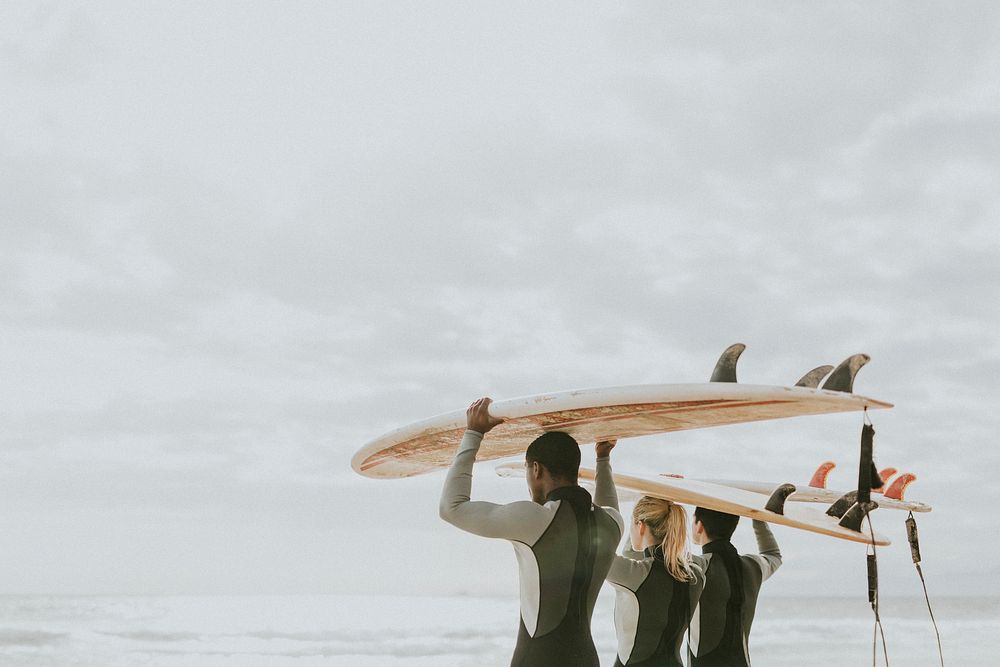 Happy friends surfing at the beach