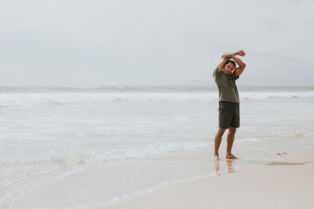 Black man stretching on the beach