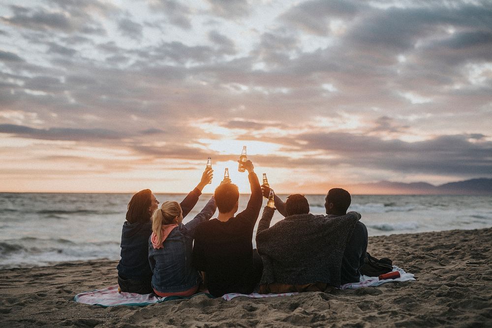 Happy friends toasting at the beach