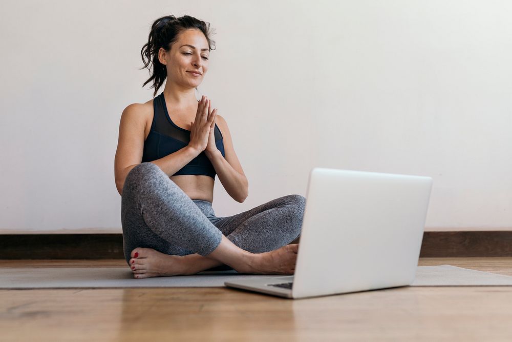 Active woman learning yoga online via a laptop