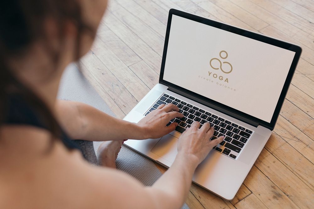 Yogini using a laptop on the floor