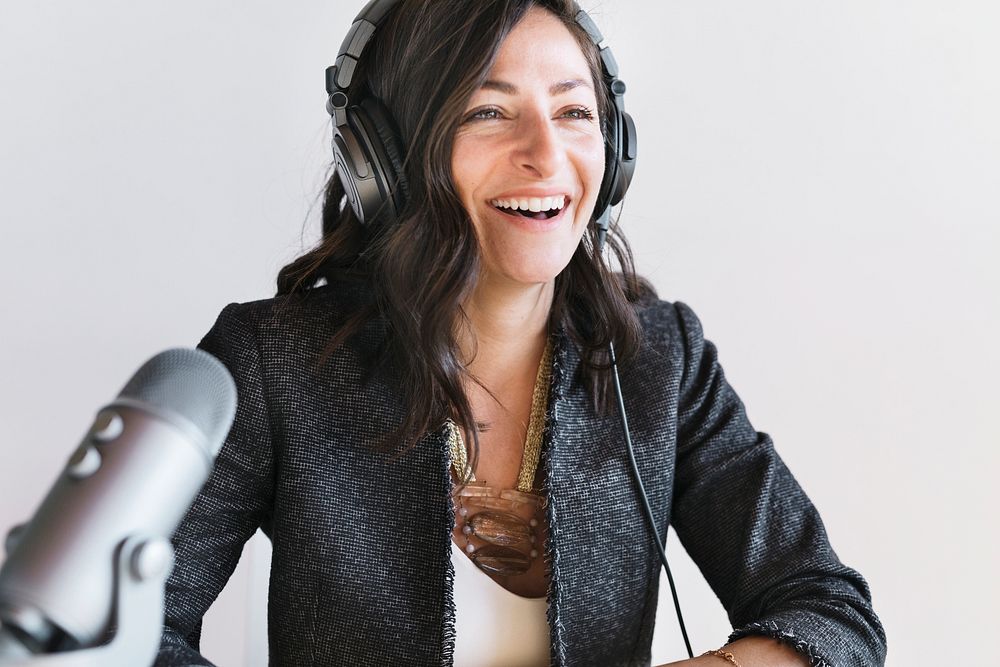 Happy female radio host broadcasting live in a studio