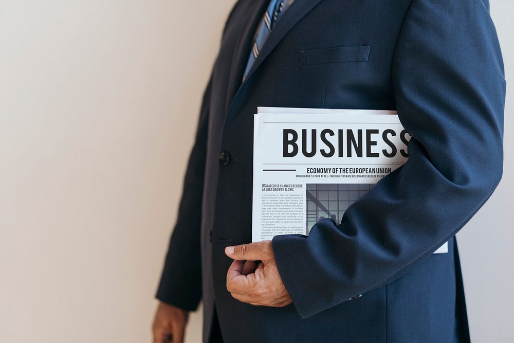 Businessman standing with a newspaper