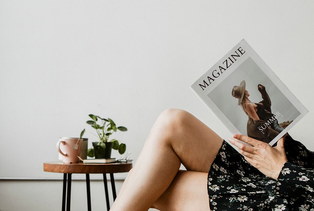 Woman with a cup of tea reading a magazine
