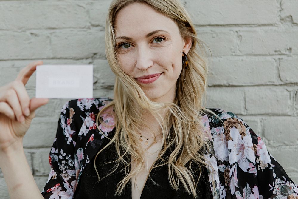 Cheerful white woman showing her business card