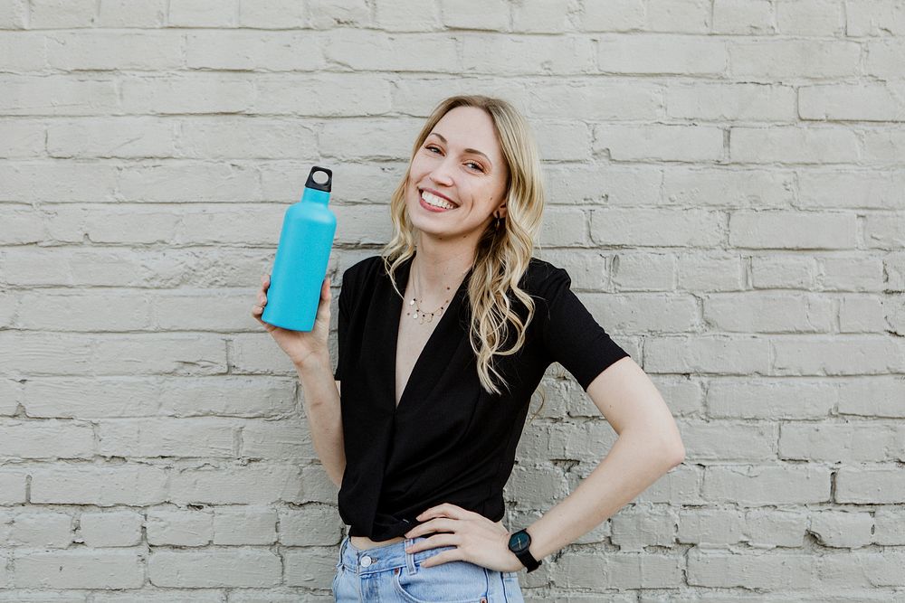 Happy woman carrying a thermal bottle