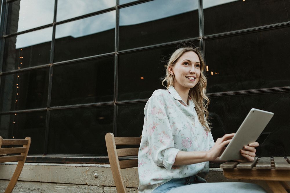 Happy woman using a digital tablet outdoors