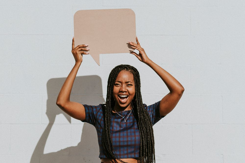 Cheerful black woman showing a blank speech bubble