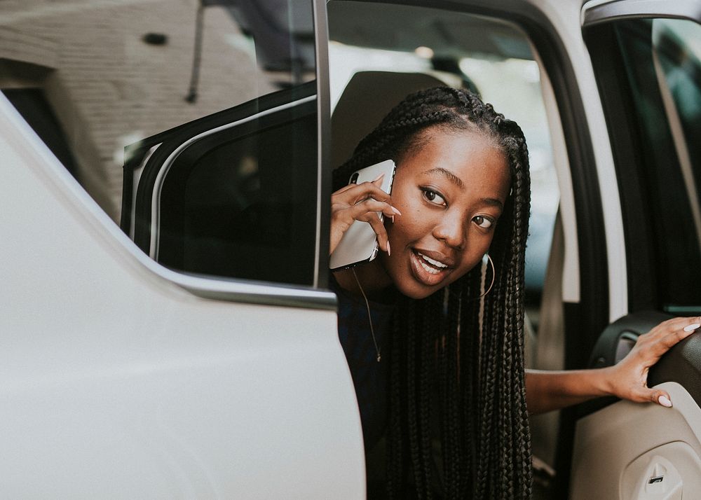 Happy woman on the phone in a car