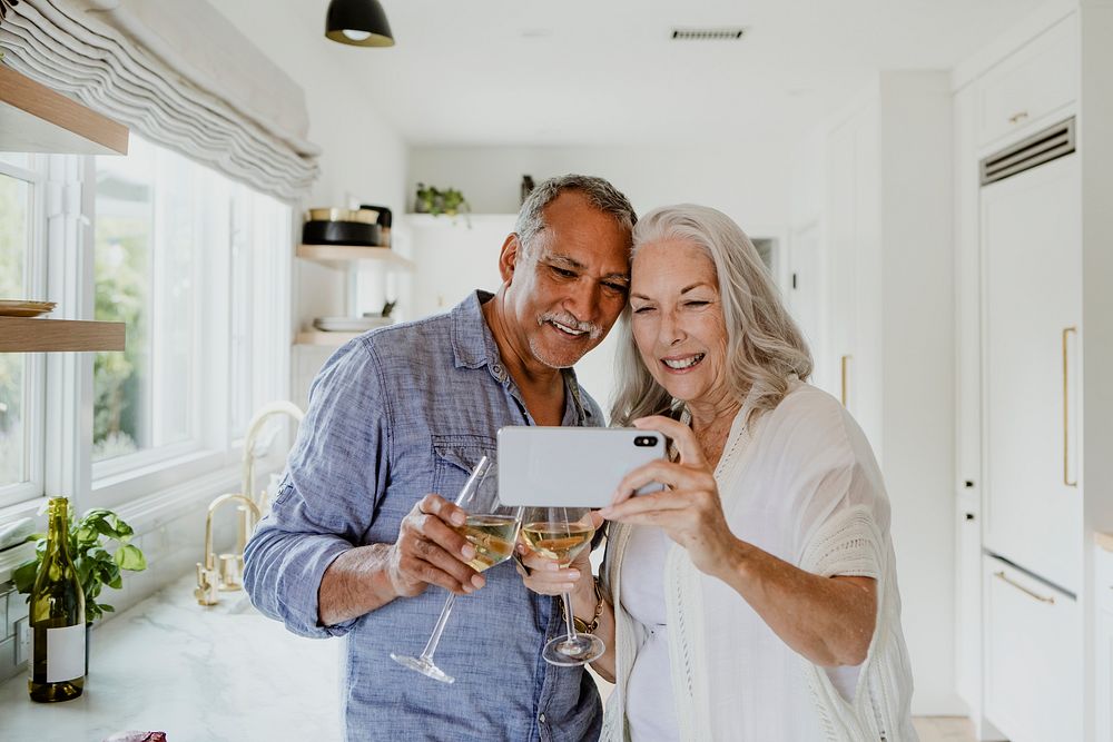 Elderly couple taking a selfie while having a wine