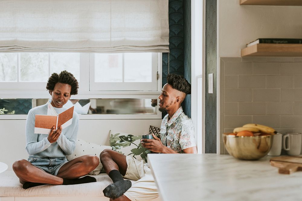 Happy black couple reading a book at home