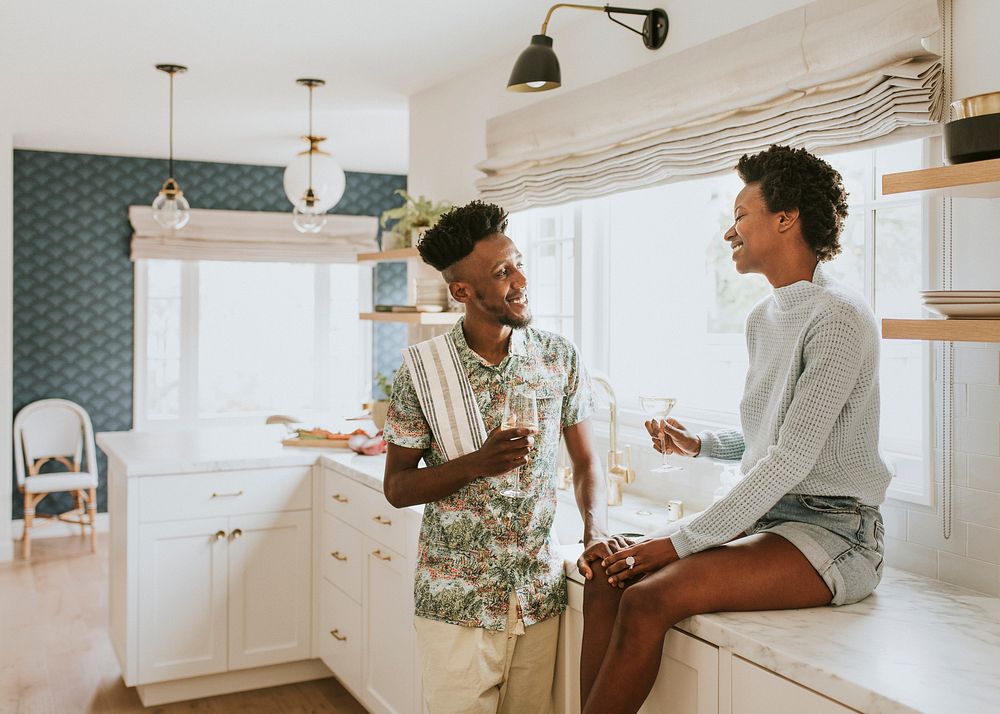 Happy couple enjoying a glass of wine in the kitchen