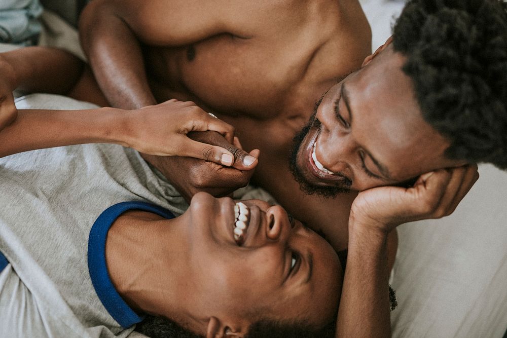 Cute happy black couple playing in bed