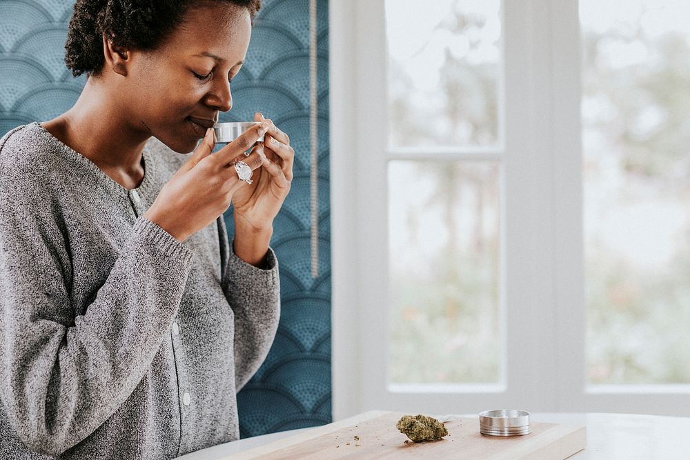 African woman smelling a weed