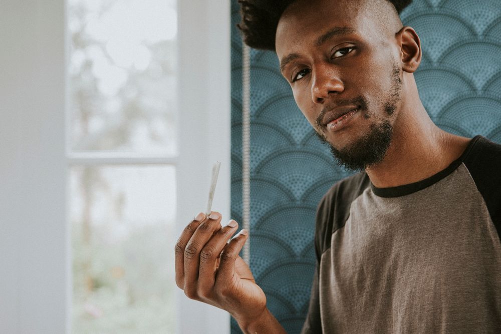 A man holding a joint in hand