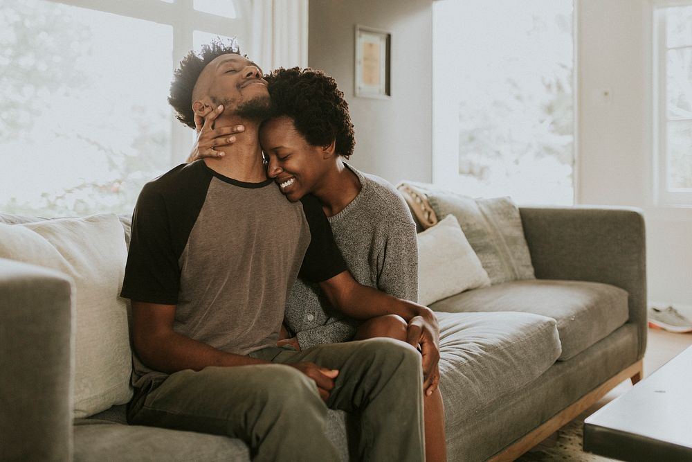 African couple chilling in a living room at home