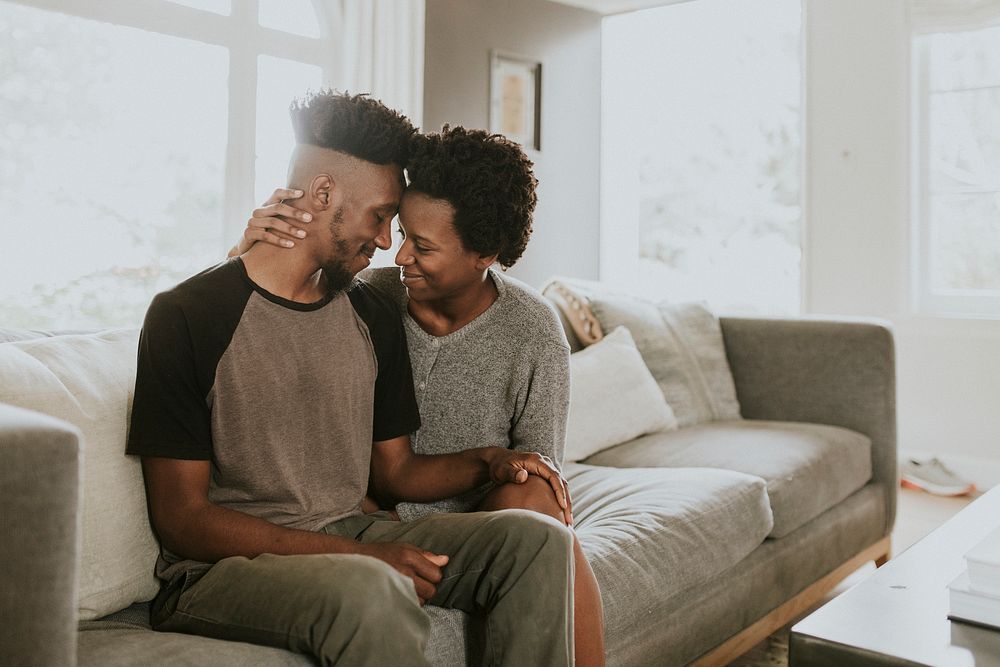 African couple chilling in a living room at home