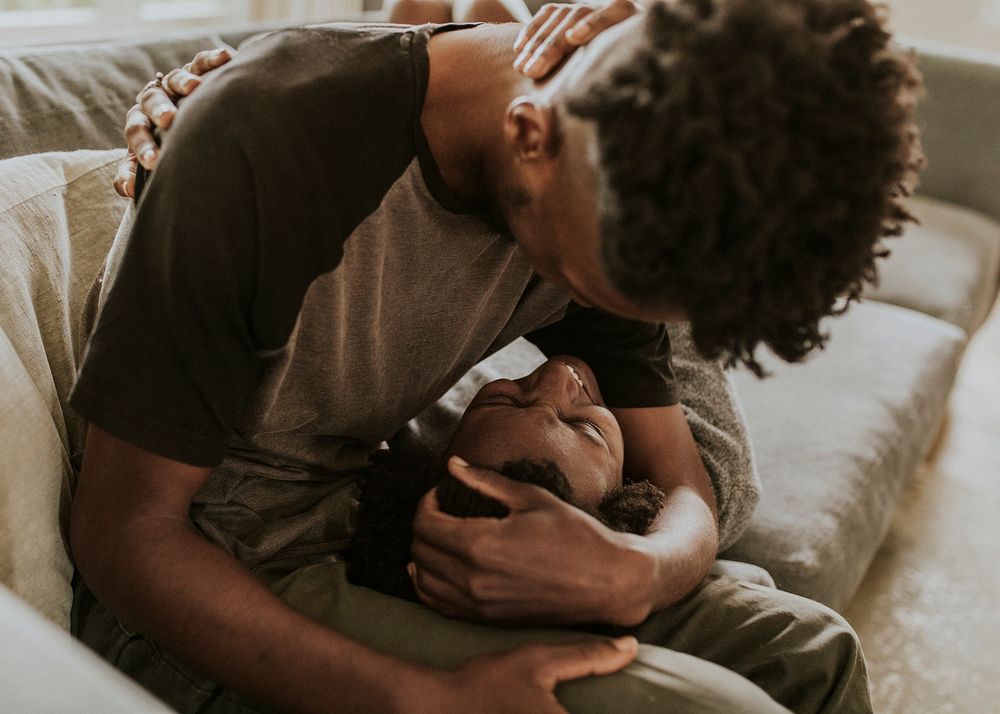 African couple chilling in a living room at home