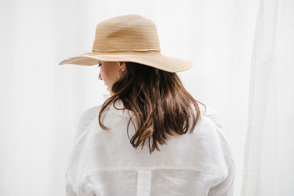 Rearview of a brown hair woman in a woven hat