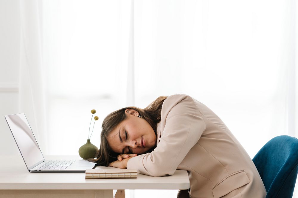 Fatigued woman napping over her laptop