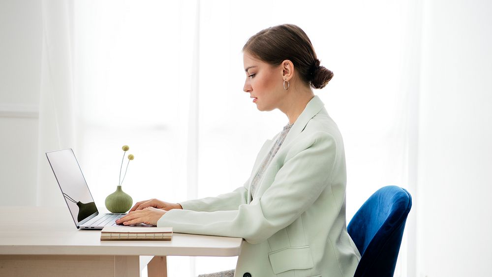 Businesswoman typing on her laptop on a wooden table