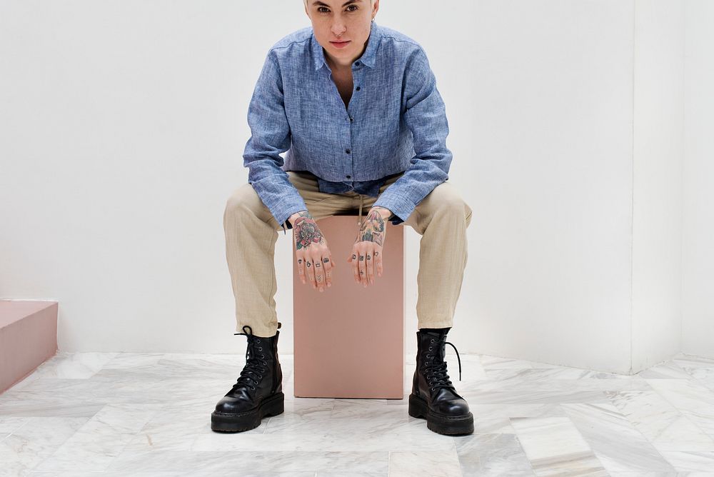 Cool woman sitting on a pink box