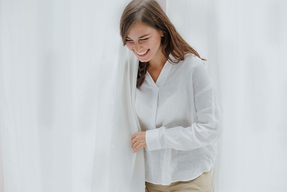 Smiling woman by the white curtain