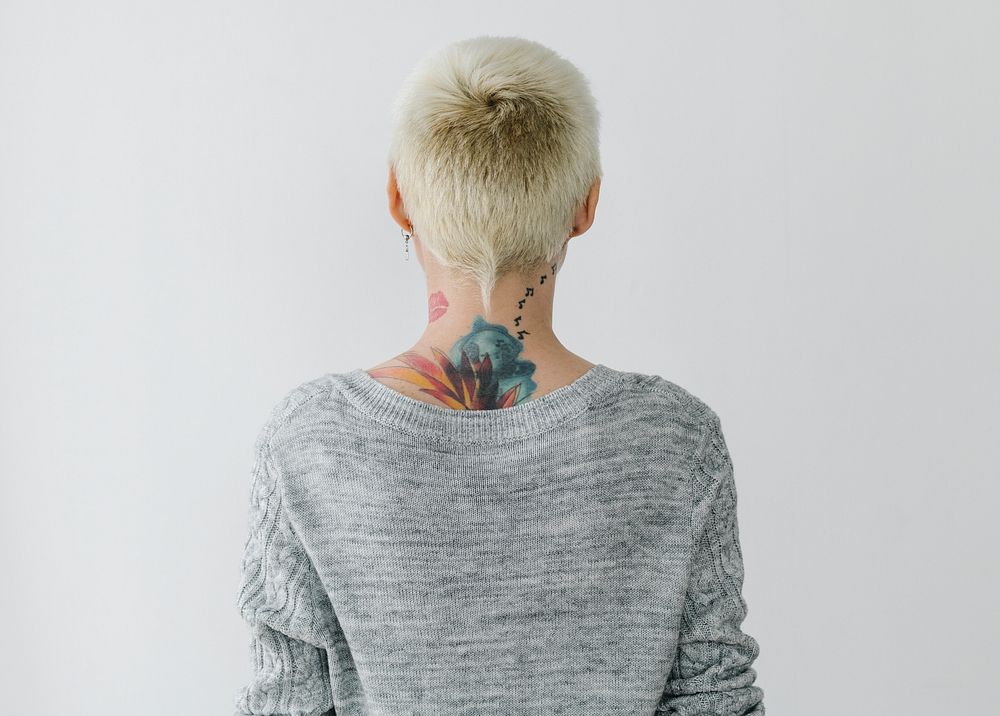 Rearview of a tattooed woman in a gray sweater
