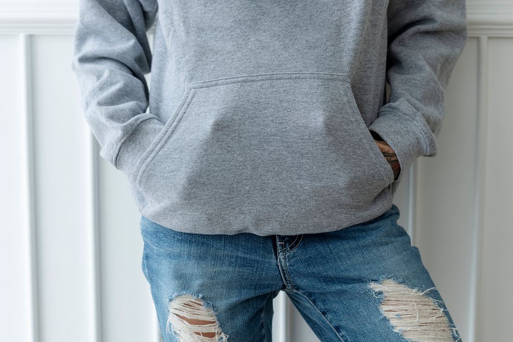 Cool woman in a gray hoodie with a ripped jeans