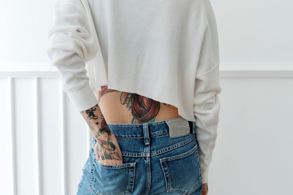 Tattooed woman tucked her hand in a jeans back pocket