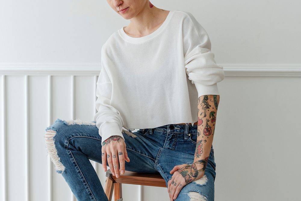 Cool tattooed short hair woman in a ripped jeans