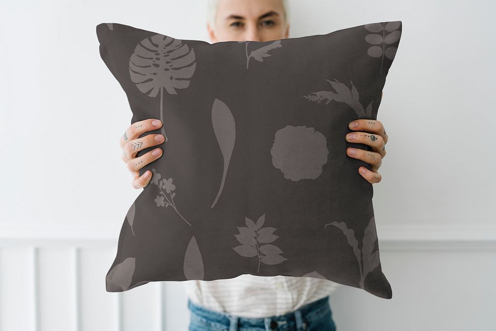 Woman holding a leafy black pillow mockup