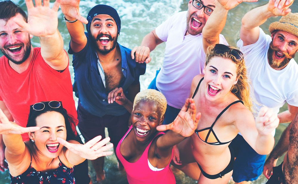 Group of diverse friends hanging out at a beach
