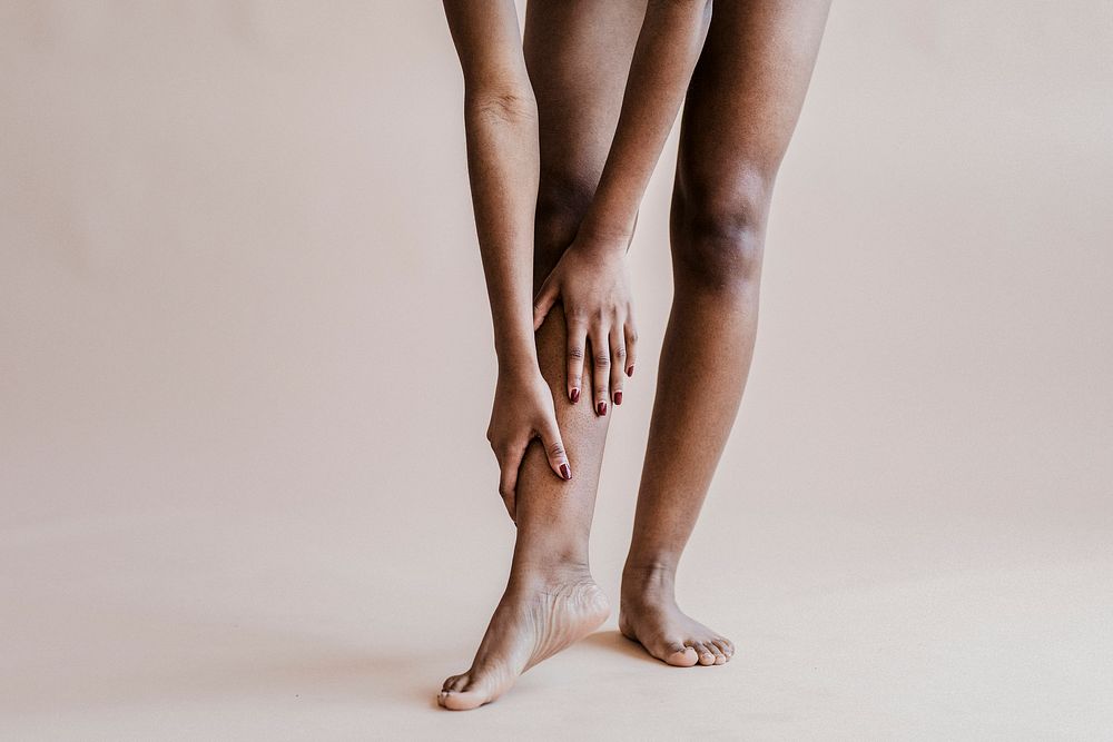 Black woman touching her sore leg