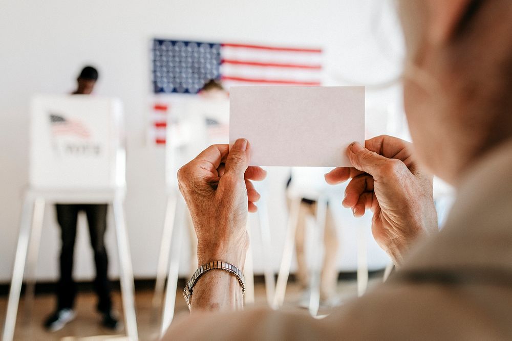 Elderly woman showing ballot up in the air